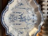 a blue and white plate sitting on top of a wooden cabinet