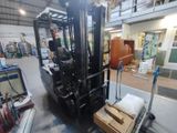 a forklift in a warehouse with boxes on the floor
