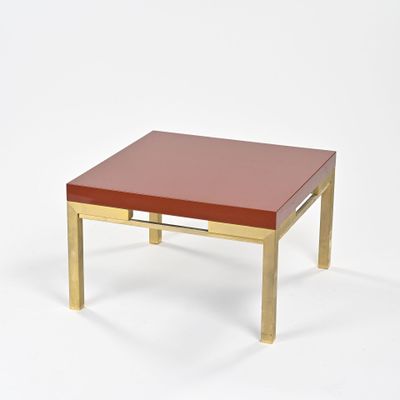 une image représentant une table basse rouge et dorée sur fond blanc