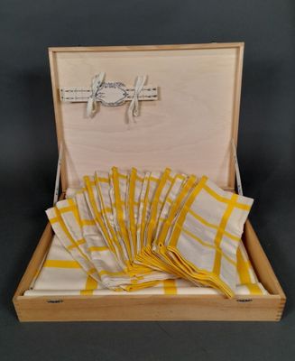 yellow and white napkins in a wooden box on a black background