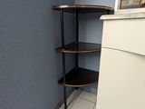 une étagère d'angle dans un coin de la salle de bains