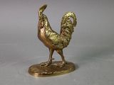 a gold statue of a rooster standing on a base