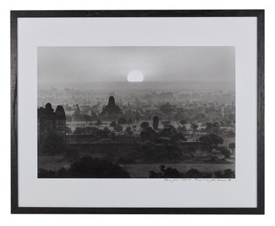 photographie en noir et blanc du soleil se couchant sur une ville