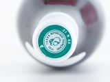 a close up of a bottle of wine on a white surface