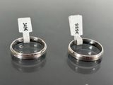 two silver rings with tags attached to them on a table