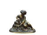 une statue de femme assise sur un rocher avec un chien