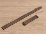 deux morceaux de cuir posés sur une surface en bois, avec un bracelet de montre