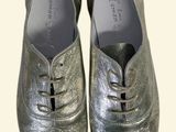 pair of silver shoes with laces on them on a white background