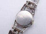 a close up of a watch on a white surface