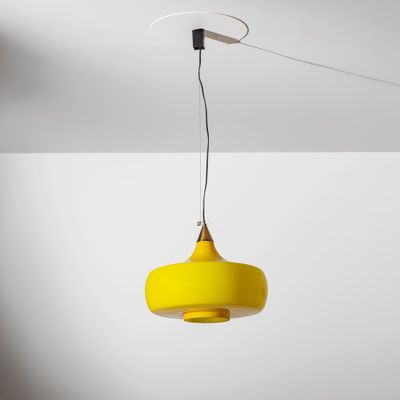 une lampe jaune suspendue au plafond dans une pièce blanche