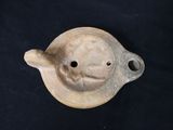 a small clay teapot with a lid on a black table