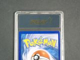 the pokemon card is in a clear plastic case