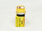 yellow toy car sitting on top of a yellow box on a white surface