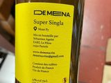 someone is holding a bottle of olive oil with a label on it