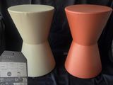 two different colored stools sitting next to each other