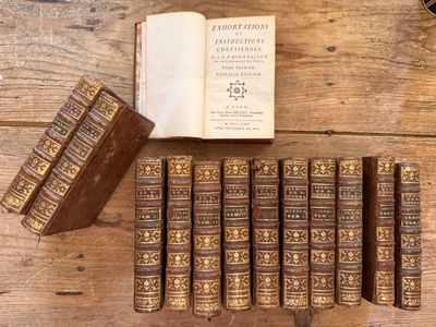 plusieurs vieux livres sont alignés sur une table en bois