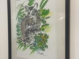 painting of a raccoon in a frame hanging on a wall