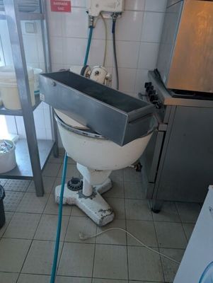 une photo d'une salle de bains avec des toilettes et une machine à laver