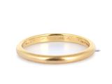 un gros plan d'une bague en or jaune sur fond blanc