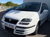 la photo d'une voiture blanche garée devant un bâtiment
