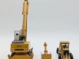 two toy construction vehicles that are sitting next to each other