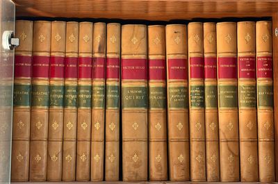 de nombreux livres anciens dans une boîte en bois posée sur l'étagère