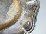 a close up of a silver plate with a bird on it