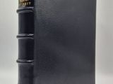 un livre noir à la reliure dorée et à la couverture noire