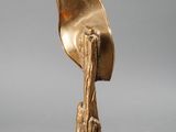 bronze sculpture of a hand holding a leaf on a wooden base