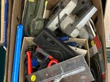 une boîte remplie d'outils divers posée par terre
