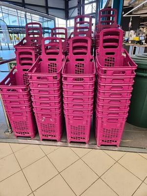 several pink plastic baskets are stacked on top of each other in a store