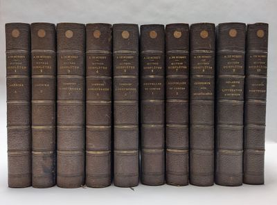 six vieux livres sont alignés sur une surface blanche