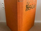 an orange book sitting on top of a carpeted floor next to a window