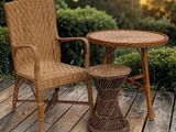 une chaise en osier et une table sur une terrasse en bois