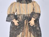 an image of a doll is dressed in a dress and bonnet