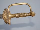 a close up of a gold colored sword with a handle
