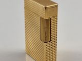l'image d'un briquet doré posé sur une surface blanche