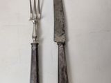 two forks and a knife on a table with a white background