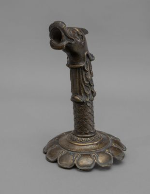 une ancienne statue en bronze représentant une femme tenant un vase