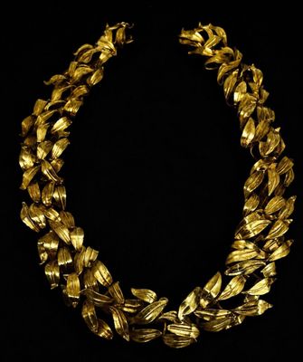 a gold necklace on a black background