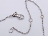 a close up of a chain on a white surface with a silver clasp