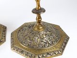 pair of antique brass candlesticks with ornate designs on the bases