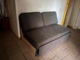 un canapé qui se trouve dans le coin d'une pièce