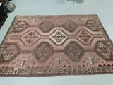 an old rug with a design on it sitting on a table