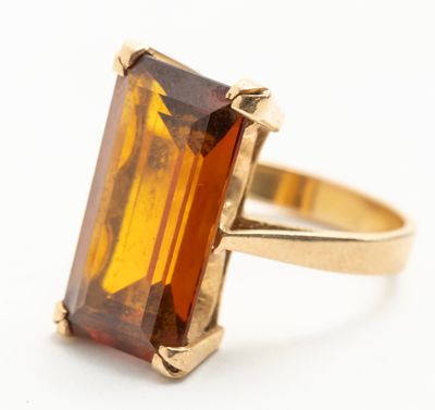 Gros plan sur une bague contenant une pierre orange