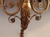 a gold sculpture on a shelf with a clock on it