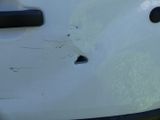 a hole in the side of a white car