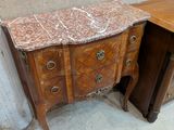 une commode en marbre dans une pièce