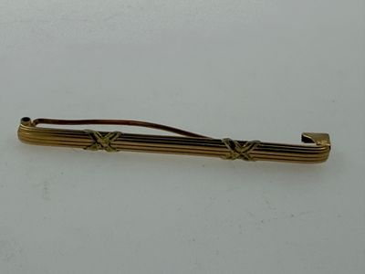 a gold colored tie bar with a knot on it