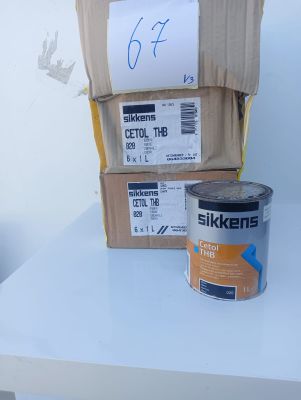 a can of paint on a table next to a stack of boxes